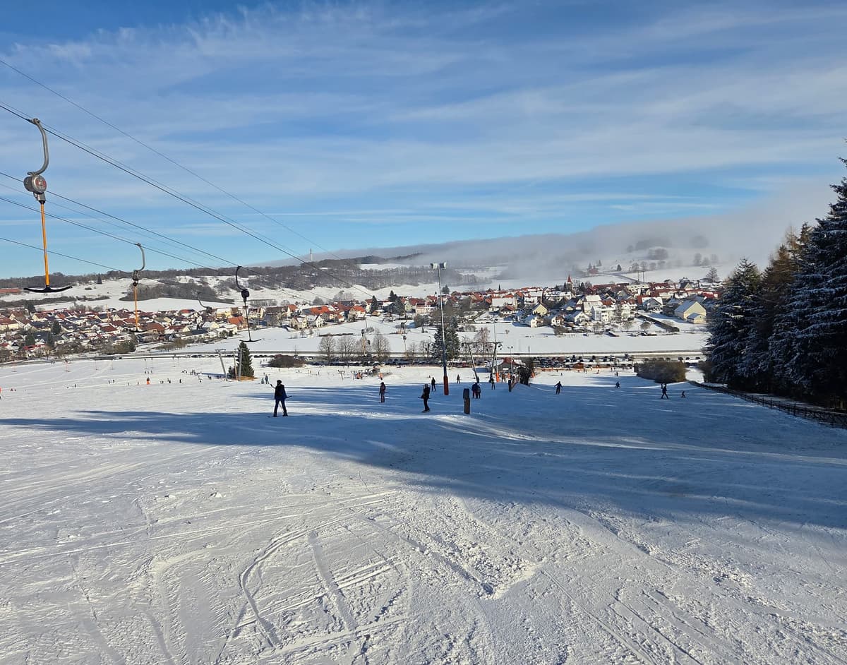 Spielplatz mit einer Rutsche und Schaukeln auf grünem Gras, ideal für Kinder zum Spielen und Entspannen.